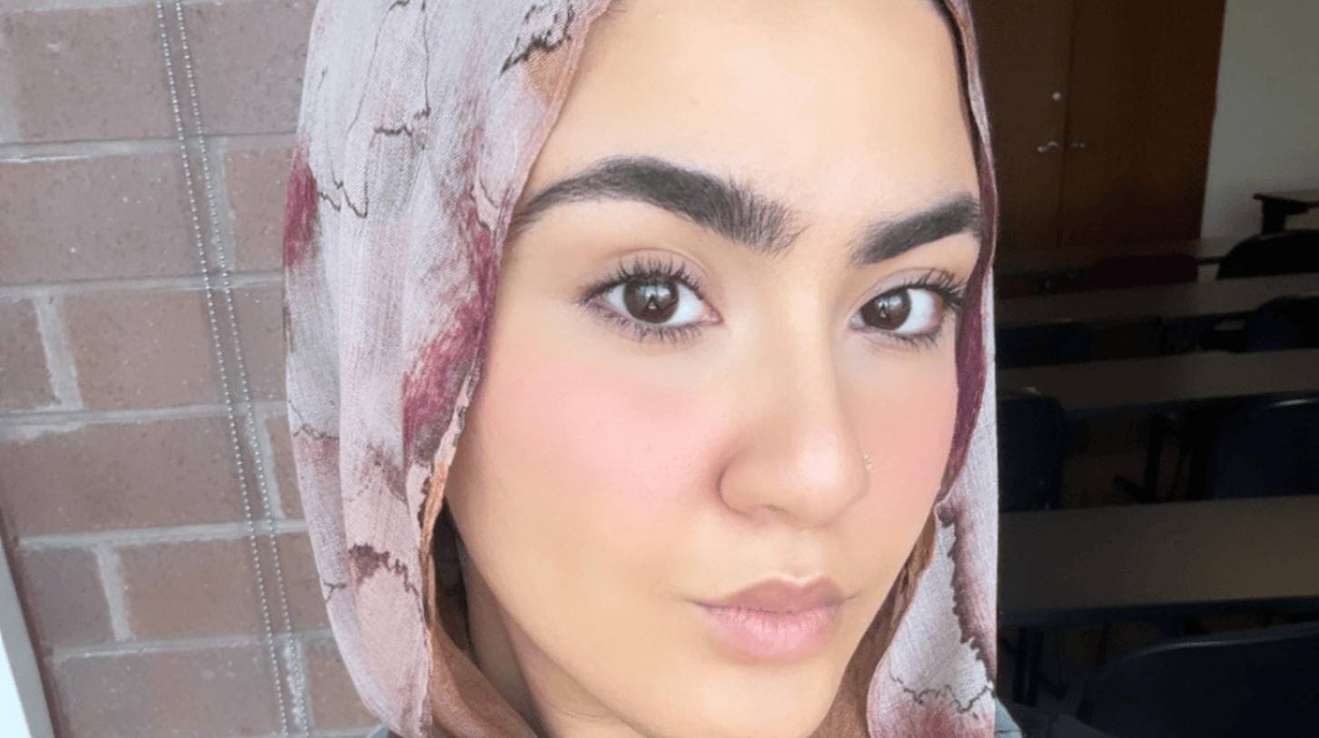 Close-up portrait of Loyola University Chicago student wearing patterned hijab, indoors near classroom wall